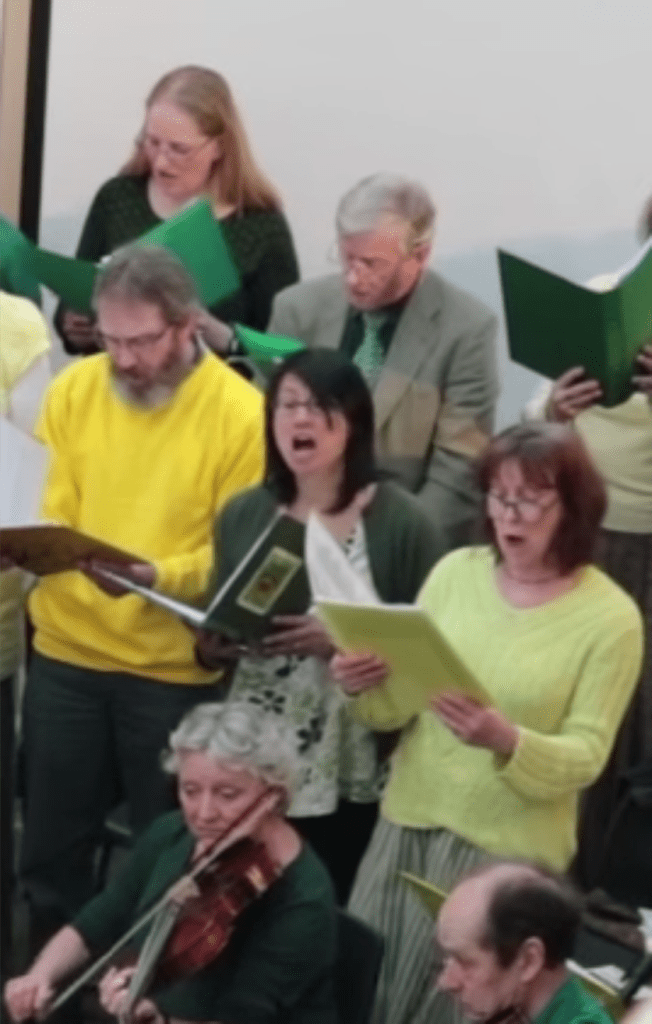Five sinhers and two viola players performing.