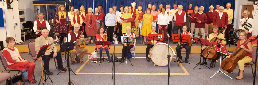Members of the Ridgeway Singers and Band on a stage