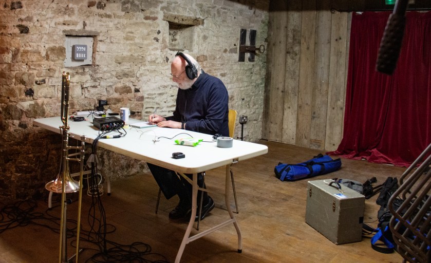 Man wearing headphones, sitting at a desk