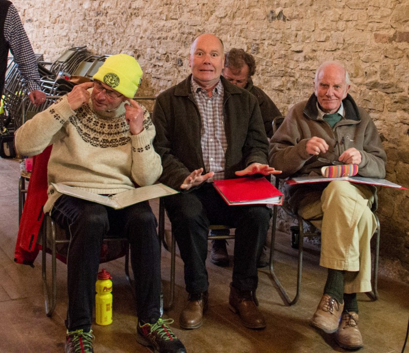 Three seated men pulling faces at the camera